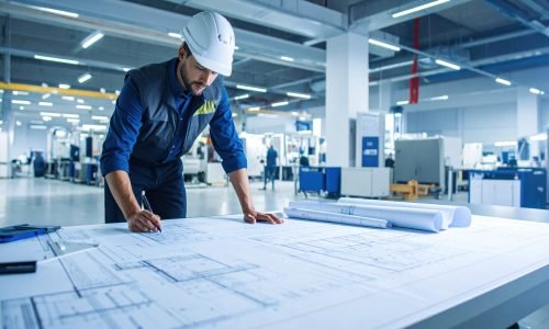 A focused engineer examines detailed blueprints in modern workspace, showcasing precision and dedication to his craft. environment is well lit and organized, enhancing productivity
